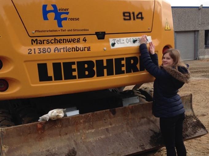 Bagger mit Firmenbeschriftung
